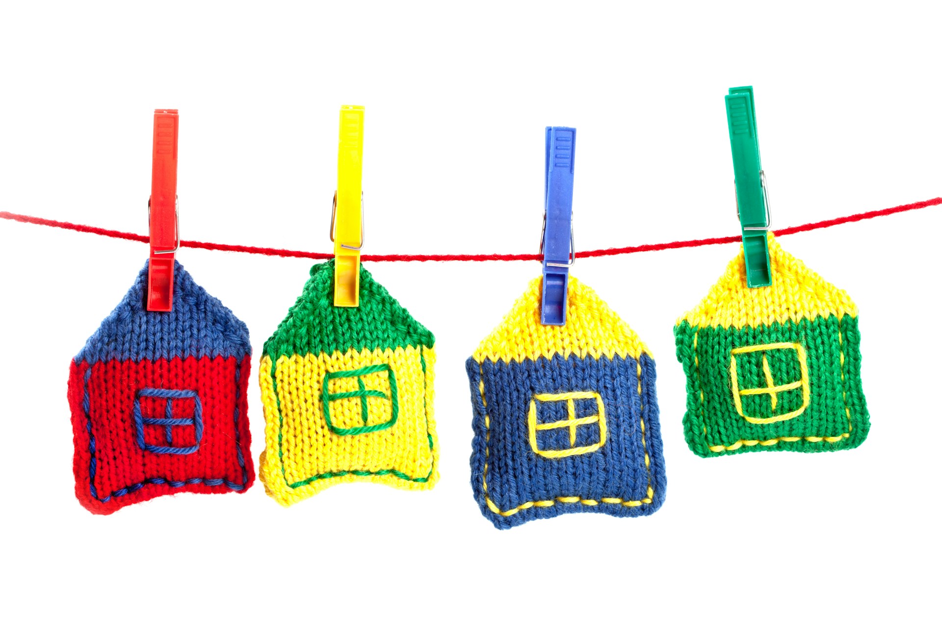 Brinquedos artesanais coloridos pendurados em corda, ambiente lúdico e seguro.